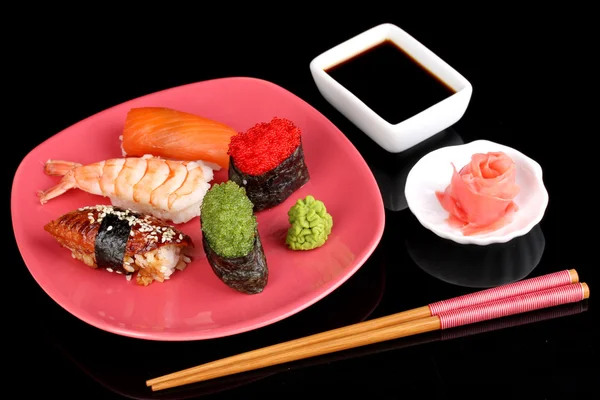 Delicious sushi served on red plate isolated on black — Stock Photo, Image