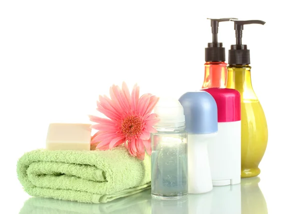Cosmetics bottles with towels and flower isolated on white — Stock Photo, Image