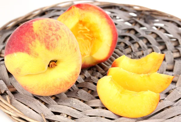 Ripe peaches on wicker mat close-up — Stock Photo, Image