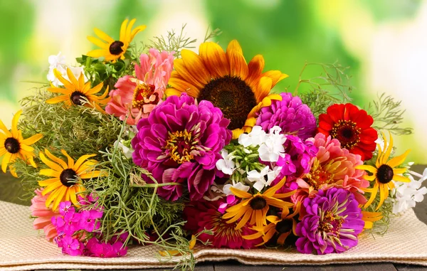 Красивый букет ярких цветов на деревянном столе на фоне природы — стоковое фото