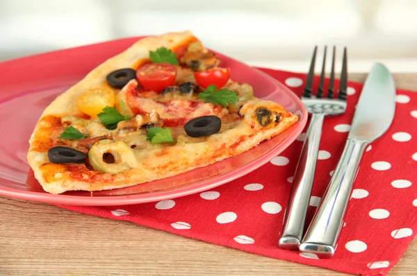 Piatto con una fetta di deliziosa pizza su fondo di legno — Foto Stock