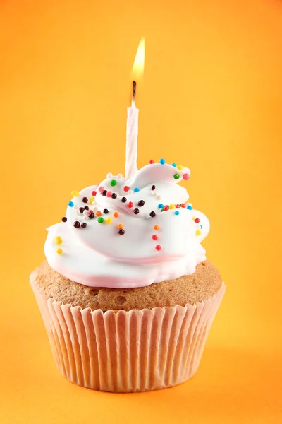 Välsmakande födelsedag cupcake med ljus, på orange bakgrund — Stockfoto