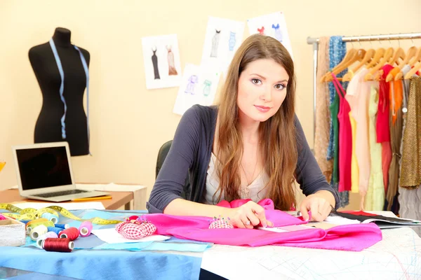 Beautiful young dressmaker in workroom Stock Photo