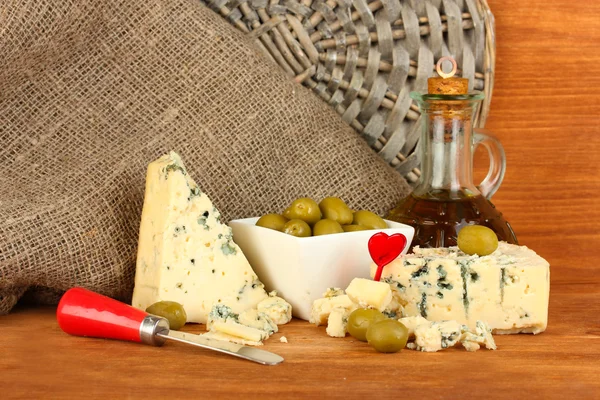 Composition of blue cheese and olives in a bowl on wooden background close-up — Stock Photo, Image