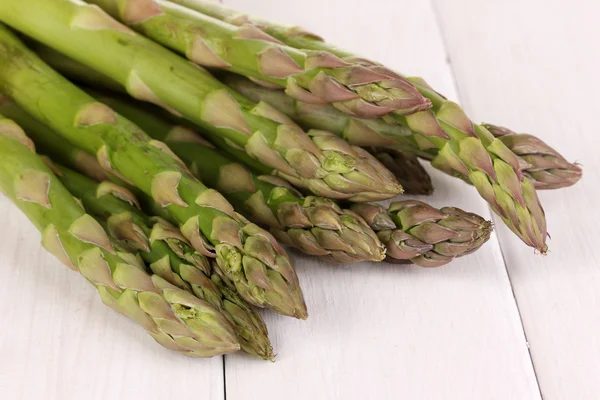 Asperges fraîches sur fond de table en bois blanc — Photo