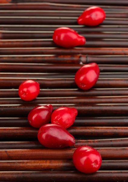 Fresh cornel berries on bamboo mat — Stock Photo, Image