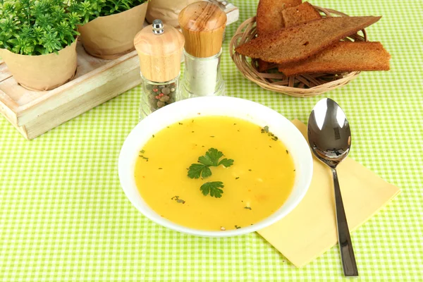 緑のテーブル クロスのクローズ アップに白色板の香りスープ — ストック写真