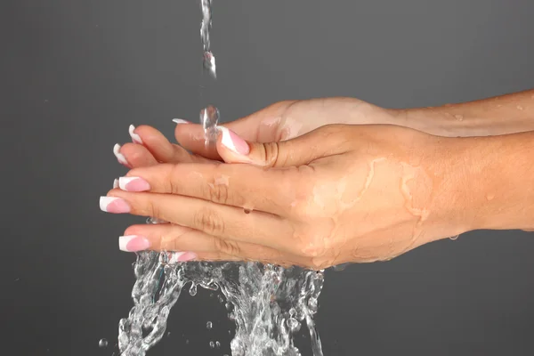 Wassen van de handen van de vrouw op grijze achtergrond close-up — Stockfoto