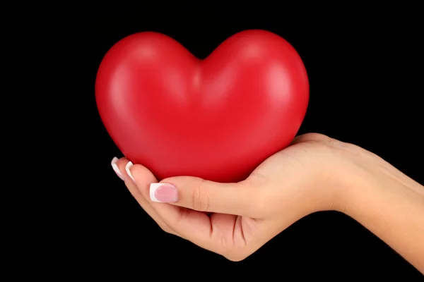 Red heart in woman's hand, on black background close-up — Stock Photo, Image