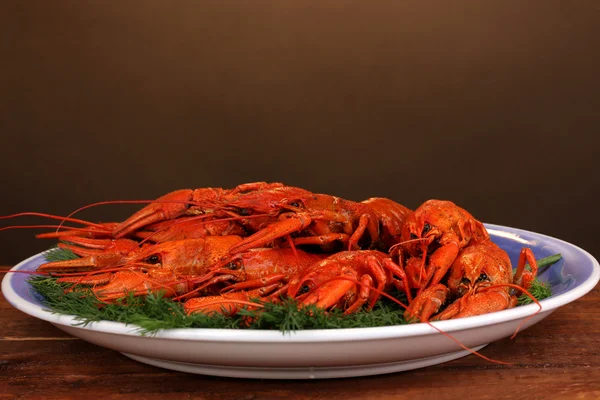 Tasty boiled crayfishes with fennel on table on brown background — Stock Photo, Image