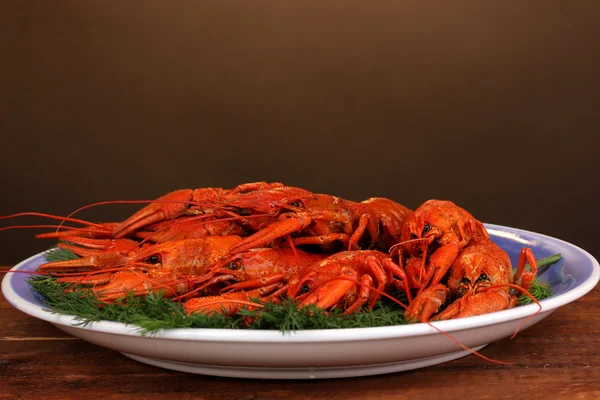 Smakelijke gekookte rivierkreeftjes met venkel op tafel op bruine achtergrond — Stockfoto