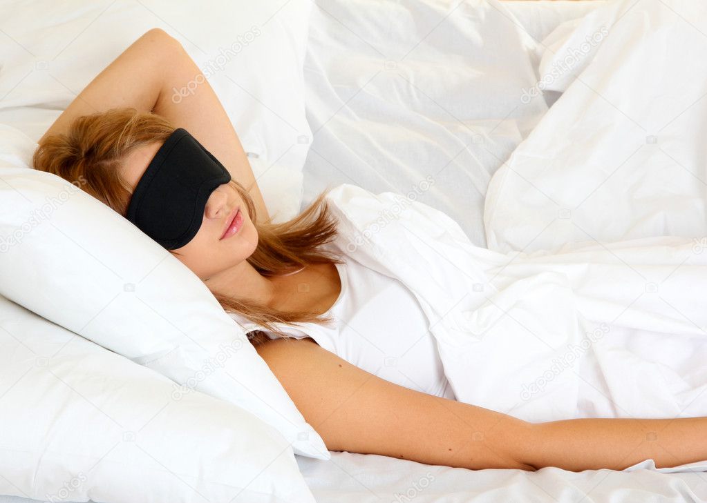 young beautiful woman sleeping in bed with eye mask