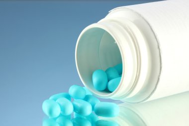 şişe mavi zemin üzerine kapsül