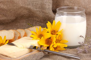 Ahşap kutusunda çevrili arka plan çuval bezi üzerinde süt ve ekmek tereyağı