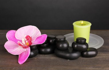 Spa taşlarla orkide çiçek ve mum gri arka plan üzerinde ahşap tablo