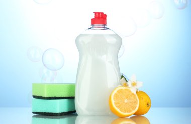 sünger ve çiçekli mavi zemin üzerine limon ile bulaşık deterjanı