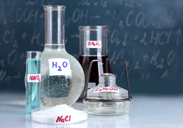 Test-tubes with various acids and other chemicals on the background of the blackboard — Stock Photo, Image