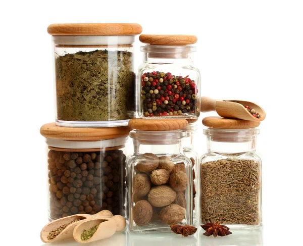 Kavanozlar ve tahta kaşıklar üzerinde beyaz izole baharatlar ile