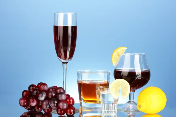 Различные алкогольные напитки на синем фоне — стоковое фото