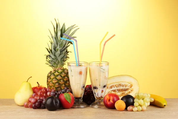 Milchshakes mit Früchten auf gelbem Hintergrund Nahaufnahme — Stockfoto