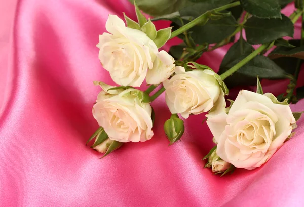 Beautiful white roses on pink satin close-up — Stock Photo, Image