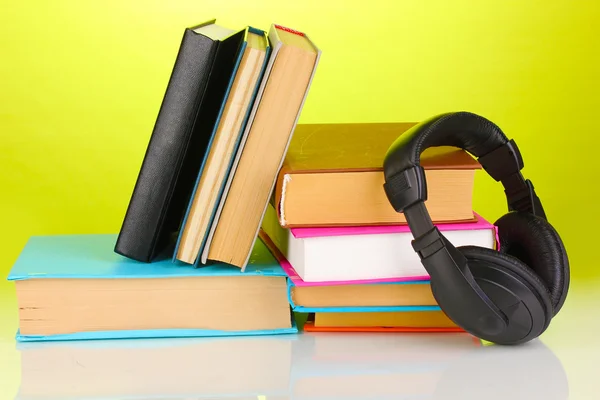 Kopfhörer auf Büchern auf grünem Hintergrund — Stockfoto