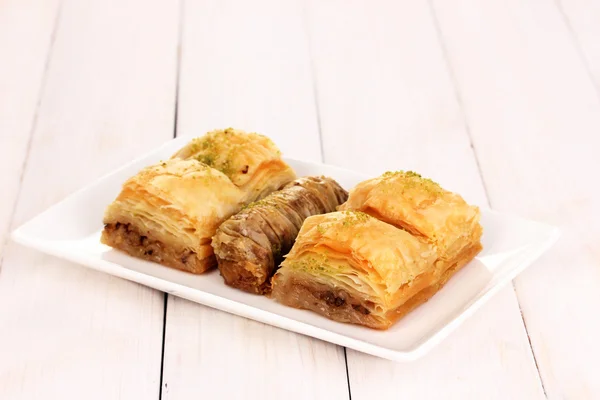 Baklava dulce en plato sobre fondo de madera —  Fotos de Stock