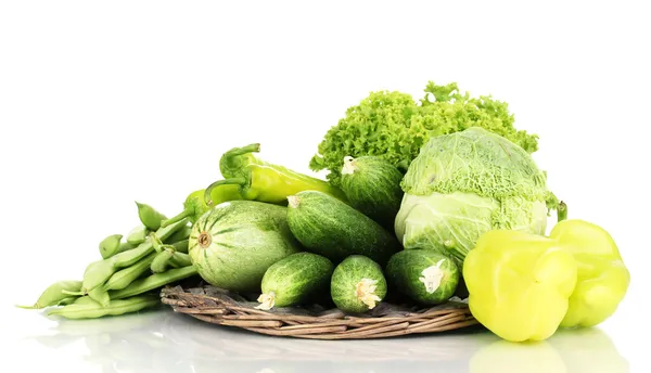 Verse groene groenten op rieten mat geïsoleerd op wit — Stockfoto