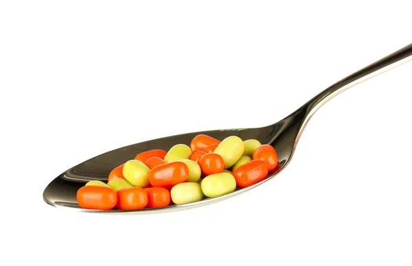 Colorful pills on spoon on white background close-up — Stock Photo, Image