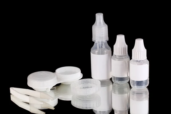 Eye drops and lenses on black background — Stock Photo, Image