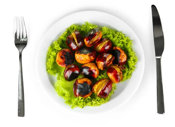 Roasted chestnuts with lettuce in the white plate with fork and knife isola — Stock Photo, Image