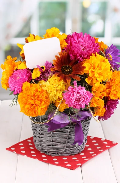 Vacker bukett av ljusa blommor med papper märka på träbord på fönsterbakgrund — Stockfoto