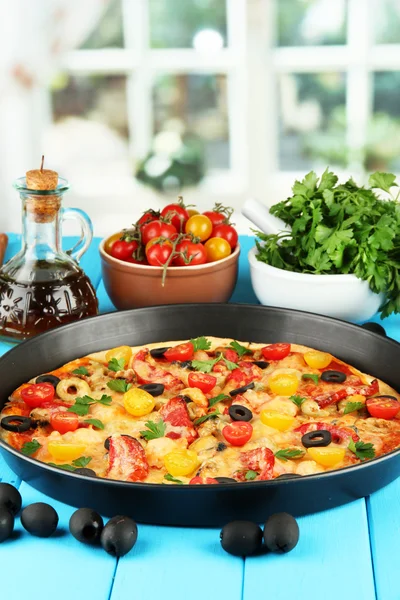 Composición colorida de deliciosa pizza, verduras y especias en madera azul —  Fotos de Stock