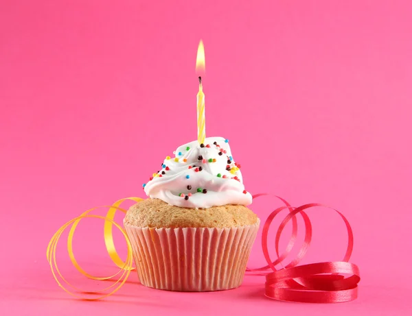 Cupcake de aniversário saboroso com vela, no fundo rosa — Fotografia de Stock