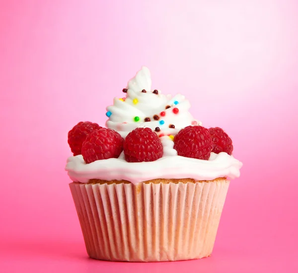 Cupcake saboroso com bagas, no fundo rosa — Fotografia de Stock