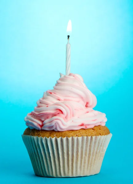 Välsmakande födelsedag cupcake med ljus, på blå bakgrund — Stockfoto