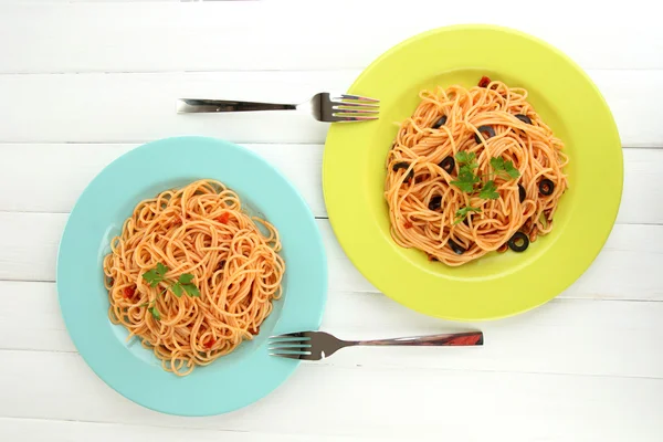 Spaghettis italiens dans des assiettes sur table en bois — Photo