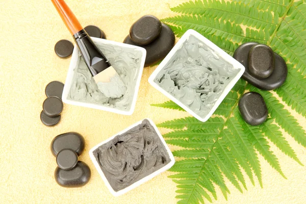 Cosmetic clay for spa treatments on yellow background close-up — Stock Photo, Image
