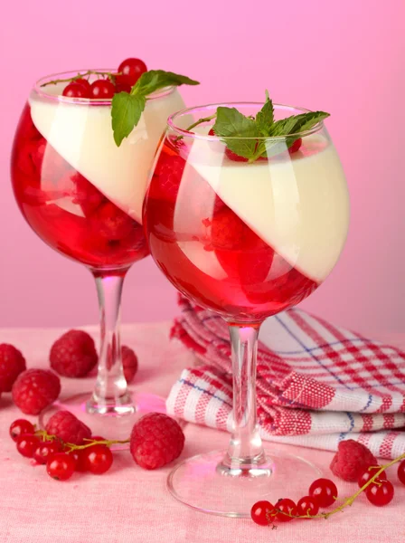 Fruchtgelee mit Beeren in Gläsern auf rosa Hintergrund — Stockfoto