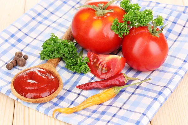 Ketchup and ripe tomatoes on wooden table — Stock Photo, Image