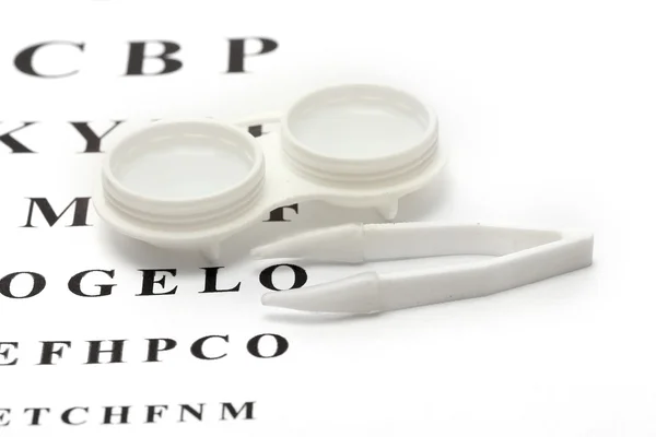 Contact lenses in containers and tweezers, , on snellen eye chart backgroun — Stock Photo, Image