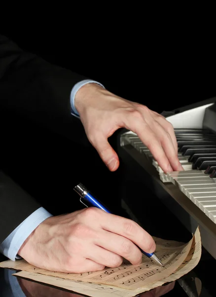 Homem mãos tocando piano e escreve sobre parer para notas — Fotografia de Stock