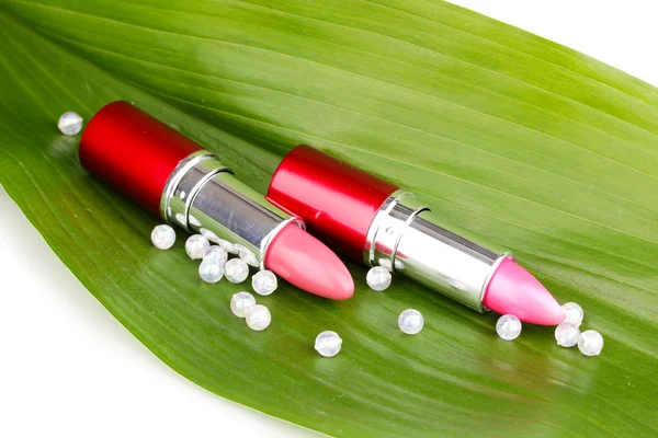 Lipsticks on green leaf isolated on white — Stock Photo, Image