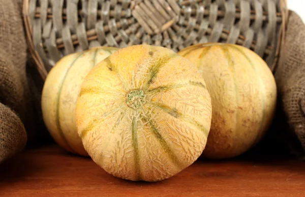 Melón dulce sobre alfombra de mimbre sobre fondo de saco de cerca —  Fotos de Stock