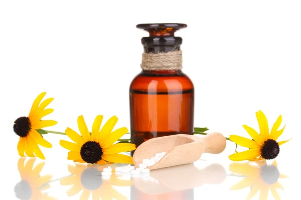 Medicine bottle with tablets and flowers isolated on white — Stock Photo, Image