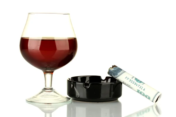 Cigar of the 100 dollar bill and an ashtray and glass of brandy isolated on — Stock Photo, Image