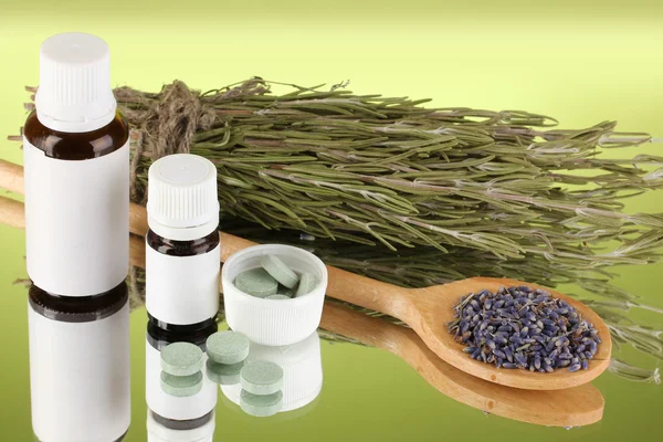 Bottles of medicines and herbs on green background. concept of homeopathy — Stock Photo, Image