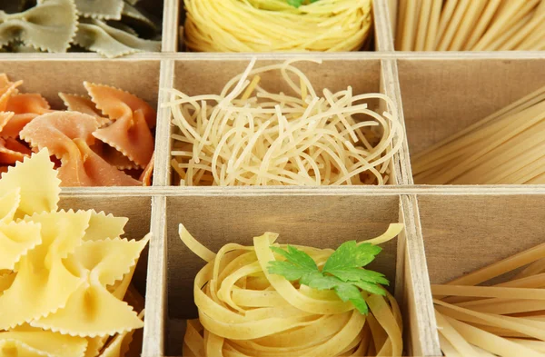 Negen soorten pasta in houten kist secties close-up — Stockfoto