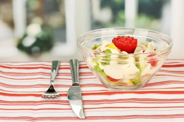 Squid salad with vegetables in a glass bowl on striped tablecloth close-up — Stock Photo, Image