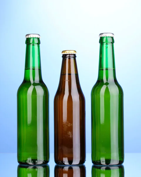 Botellas de cerveza sobre fondo azul — Foto de Stock